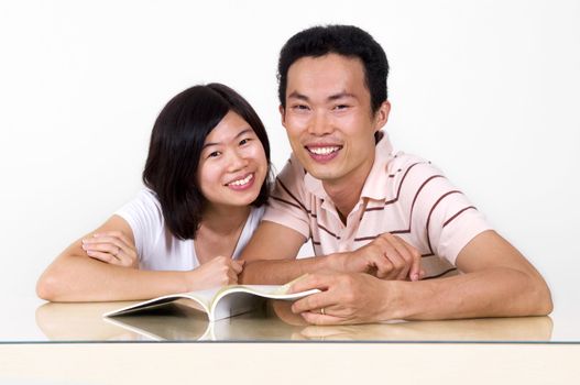 Asian couples sharing a book.