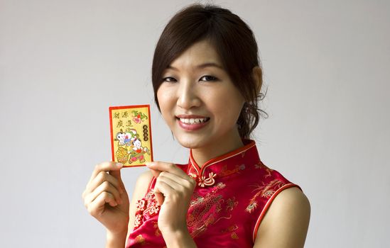 Asian female holding a red packet wishing you happy Chinese New Year