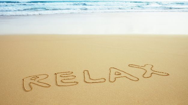 The inscription on the surface beach sand - relax