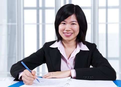 A businesswoman sitting at the table with document.