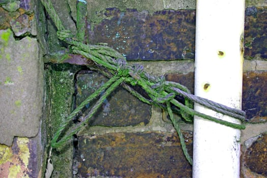 Old Green Rope Holding up White Metal Pole