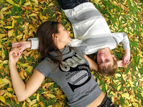 The young pair costs on a footpath in autumn park    