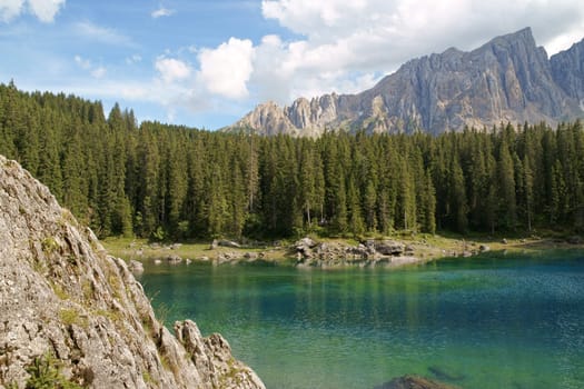 Scenic view of Carezza lake in the italian region of Trentino-Alto Adige (South Tyrol) and the Dolomites chain of the Rosengarten (Catinaccio).