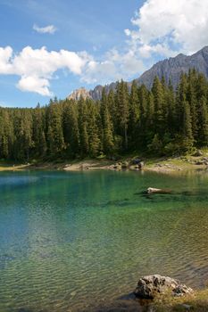Scenic view of Carezza lake in the italian region of Trentino-Alto Adige (South Tyrol) and the Dolomites chain of the Rosengarten (Catinaccio).