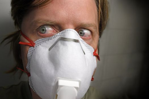 A man in his early 40's paranoid about flu viruses wearing a protective mask.
