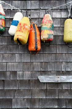 A group of old buoys hanging on a wall near the marina.
