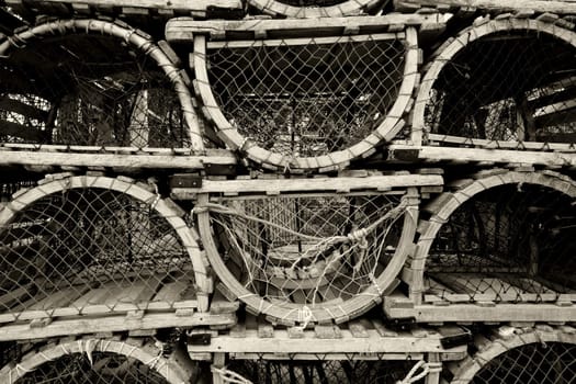 An image of old lobster traps resting by the sea.
