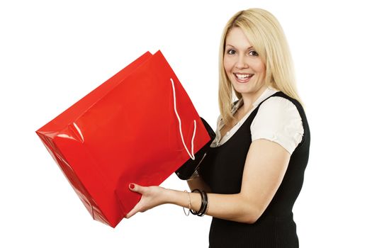 A very happy shopping girl holding a shopping bag and smiling wildly after looking into it.