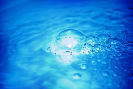 Beautiful blue bubbles floating on the water