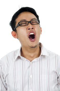 Tired and unshaved young Asian businessman yawning.