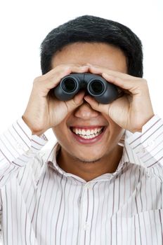 Asian young man holding a binocular peeping and smiling.