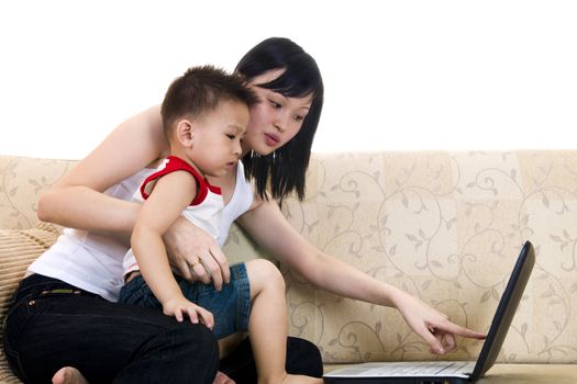 Young mother with her son using a laptop