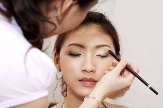 Woman applying cosmetic with applicator. Make-up treatment.