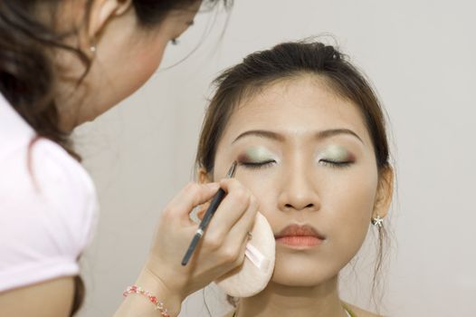 Woman applying cosmetic with applicator. Make-up treatment.