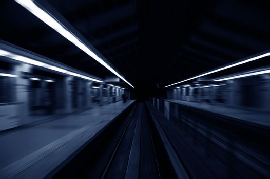 Speedy trains passing train station. Focus on the rail road. 