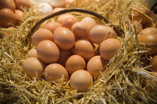 Fresh eggs in straw basket in the market.