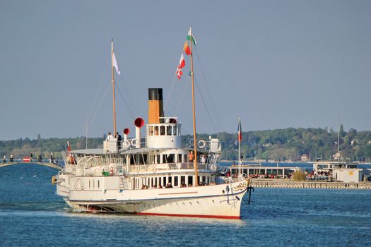 Famous old white steamboat on Geneva lake by sunset, Switzerland.