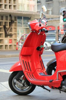 Red scooter parked in the city street