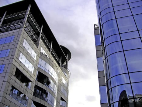 Two Reflective Modern Office Buildings on a Cloudy Day