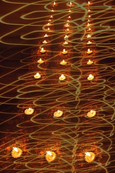 An abstract design of traditional Diwali lamps in light swirls for greetings.