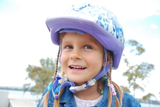 happy 5 year old girl wearing a protective helmet