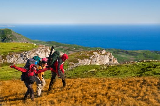 Group of hikers climbing up the rocky mountain