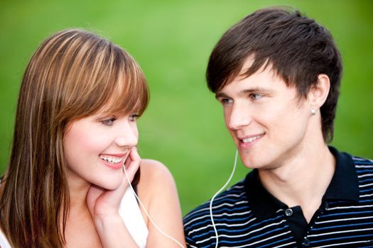 Young couple sharing a headphones while listening to a favorite  beat