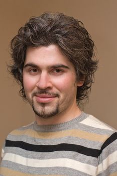 Young smiley dark haired caucasian man in striped sweater