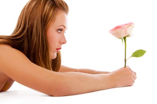 Nude girl looking at a beautiful rose