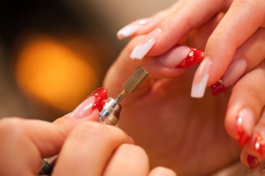 Macro closeup of nail polisher at work on french nails