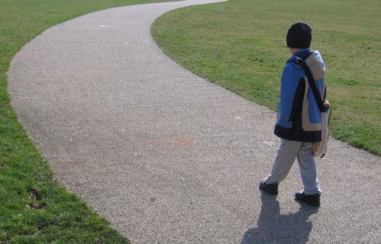 Boy on Curved Stone Chip Path on Grass Lawn in Park