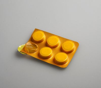 Great orange pills in a blister, over gary/white background