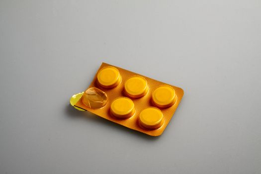 Great orange pills in a blister, over gary/white background