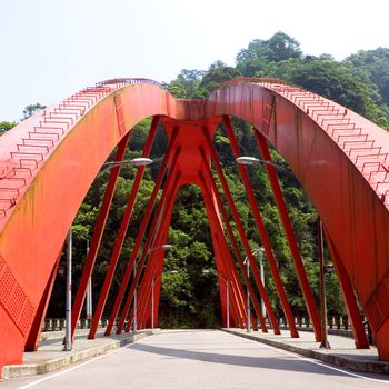 Here is a red big bridge on the land.
