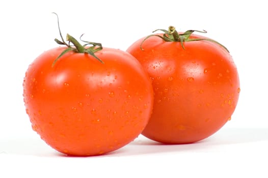 two fresh tomatoes with waterdrops isolated on white