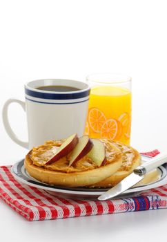 Toasted bagel with peanut butter and apple slices.