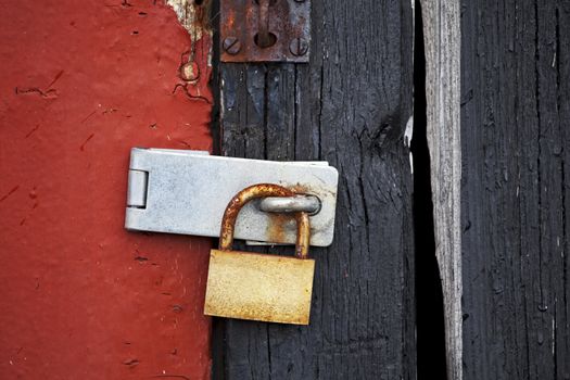 rusty old padlock on a wooden door