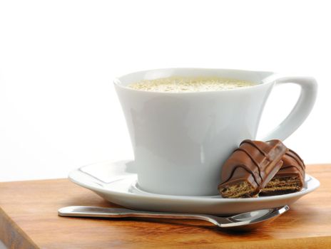 Cup of fresh brewed espresso and chocolate candy.
