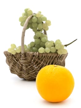 grape in basket and bright orange near it against the white background