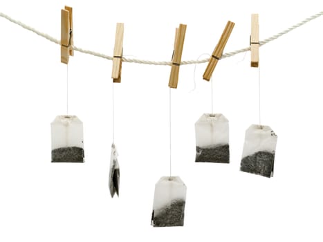  tea bags at the peg against white background