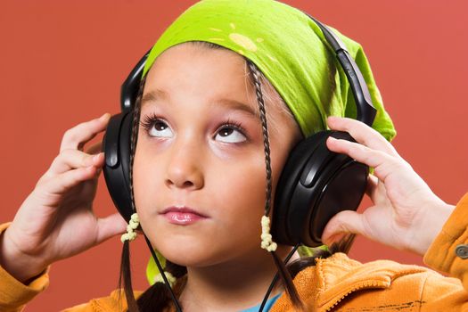 little pretty child listening music in headphones