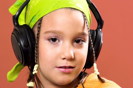 little pretty child listening music in headphones