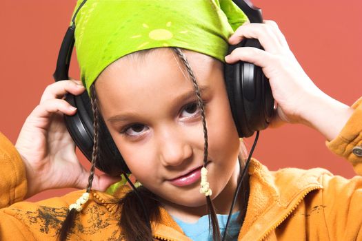 little pretty child listening music in headphones