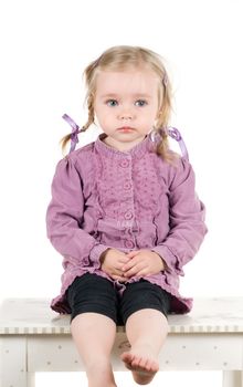 A little girl sittin on the table in studio