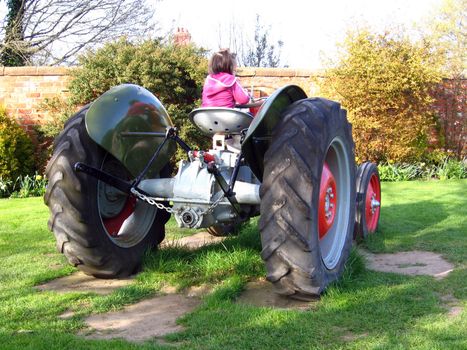 Small Girl on Old Tractor in Green English Field