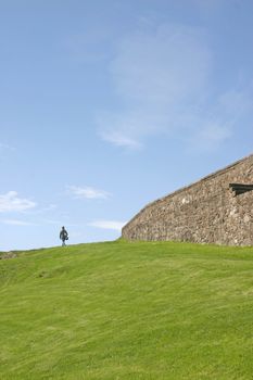 Woman Walking on Grass Bank Stirling Castle in Scotland UK