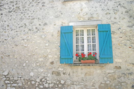 Window with Blue Shutters and Red Flowers in Stonebuilt Cottage Wall