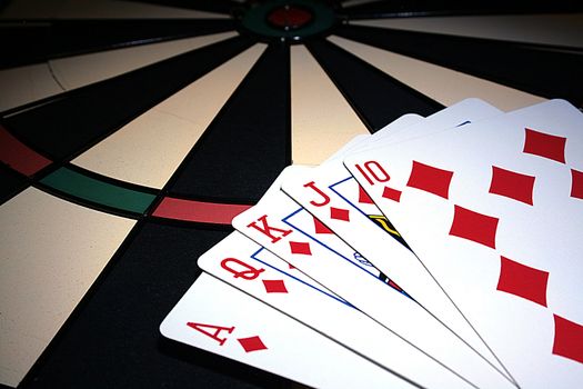 Playing cards on a board for game in a darts.