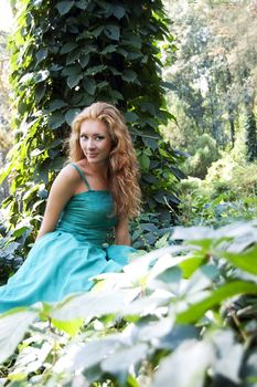 Lady in emerald dress among woods
