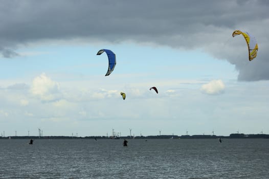 some kite surfers, surfing at the sea 